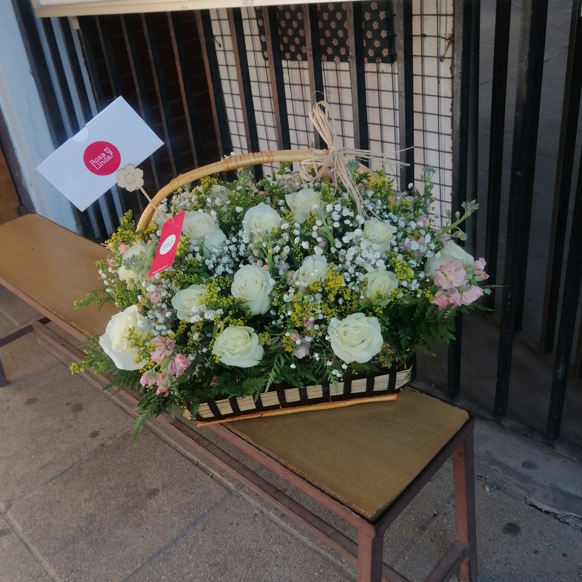 Elizabeth - Arreglo floral en canasto de mimbre con rosas blancas, alelíes rosados y solidago - Pedido 239400