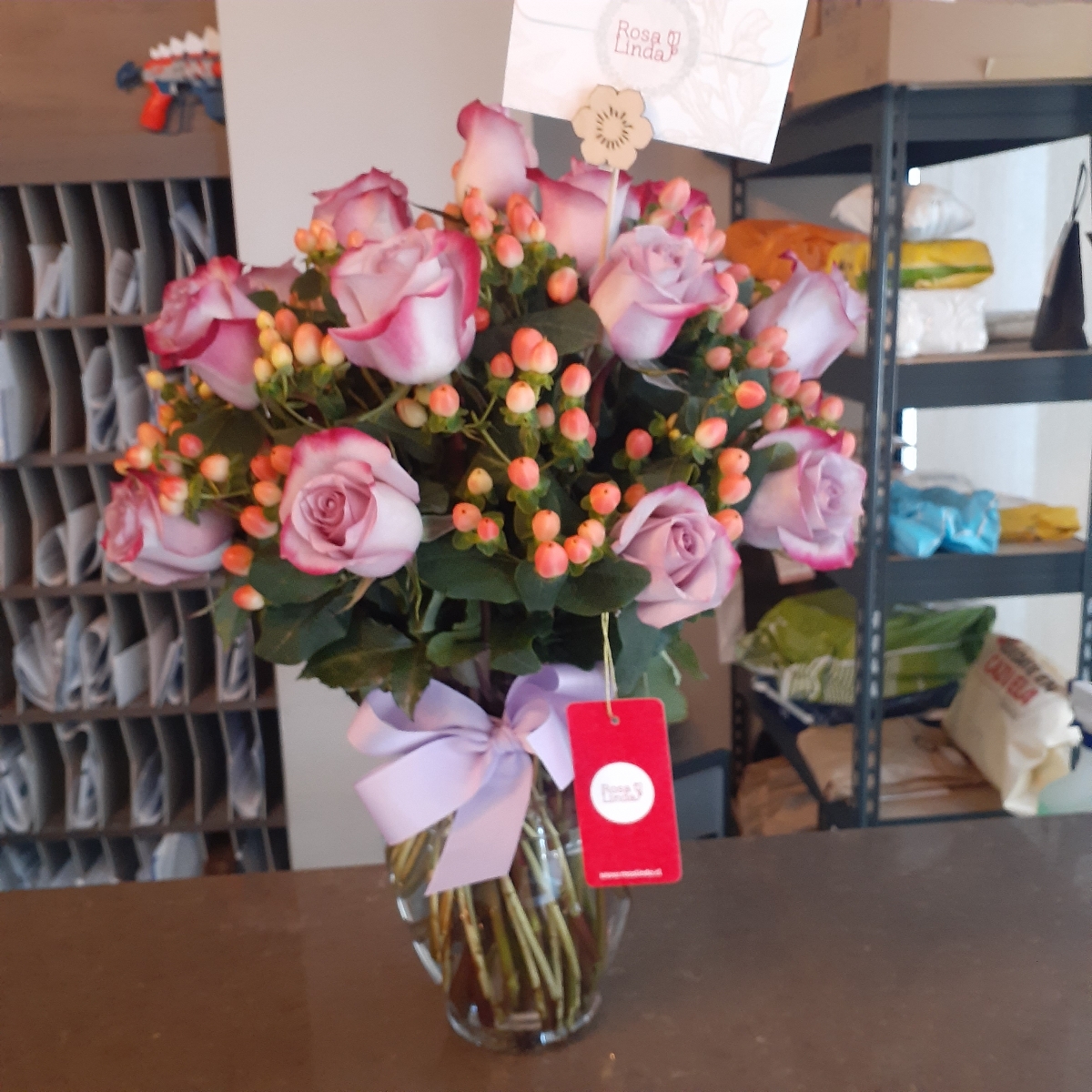 Antonia Lila - Arreglo floral en florero con 24 rosas lilas e hypericum rosado - Pedido 247617